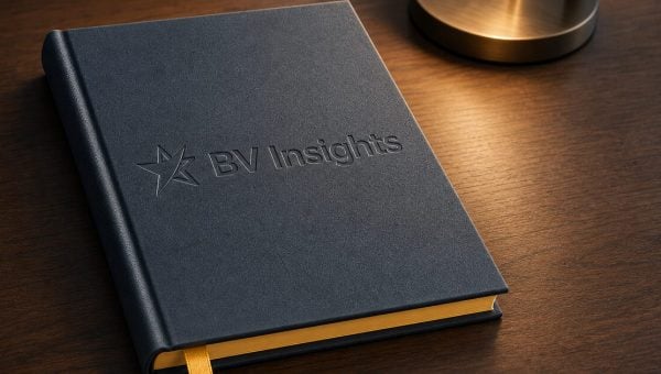 BV Insights journal on a dark wooden desk under warm lamp light